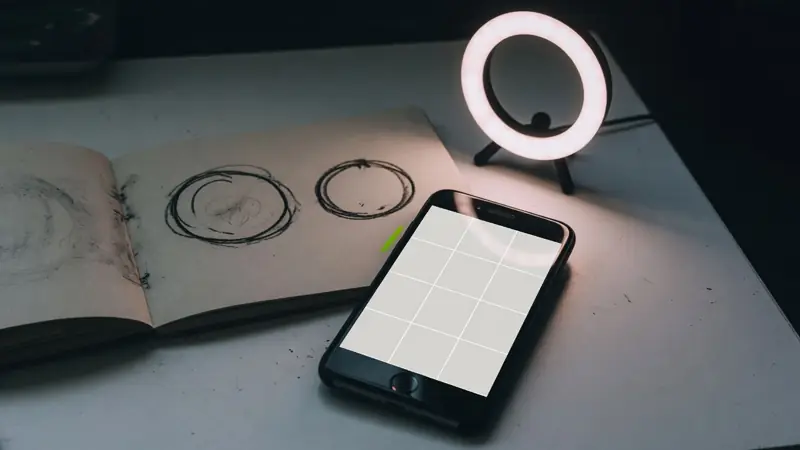 Illustration of a phone showing an empty photo grid next to a ring light